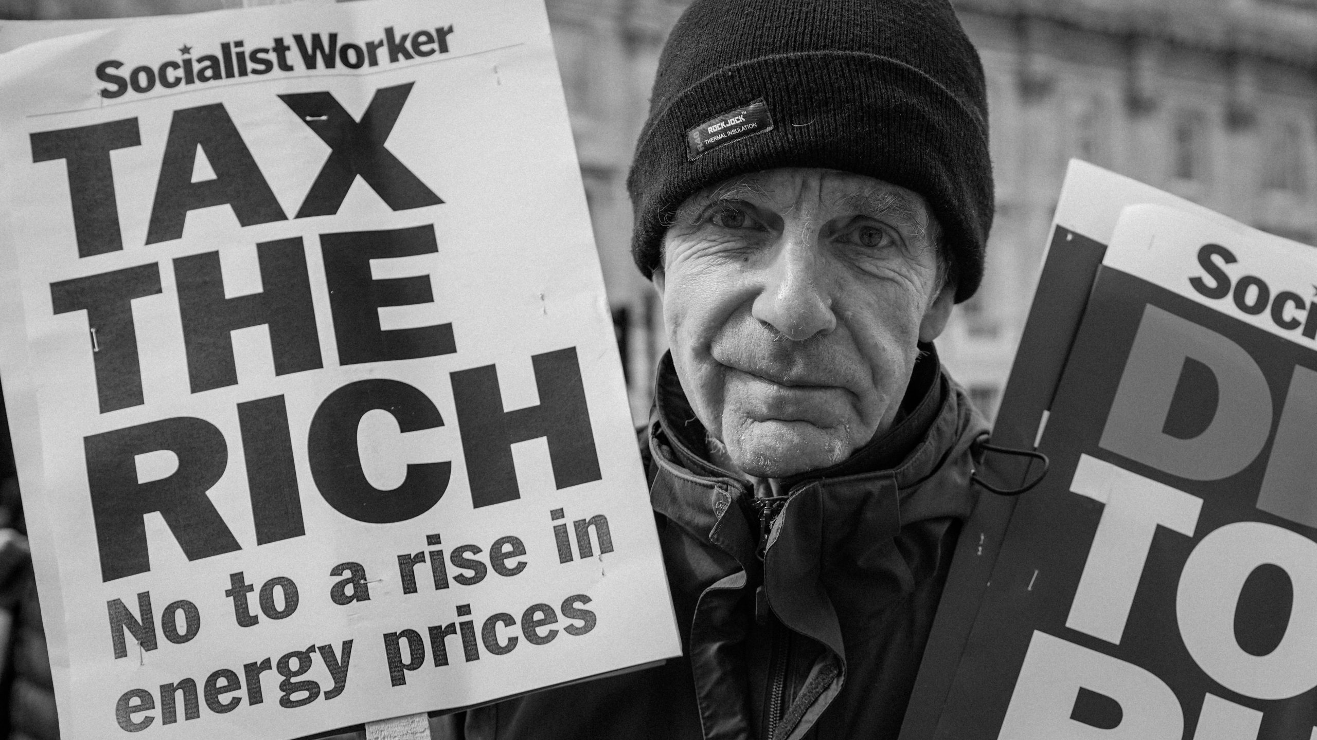 Demonstrant met het bord ‘Belasting heffen op de rijken’, Londen, VK, 2022 (Foto: Alisdare Hickson, <a href='https://commons.wikimedia.org/wiki/File:Tax_the_Rich_!_%2851982704885%29.jpg' target='_blank'>Wikimedia Commons</a>)