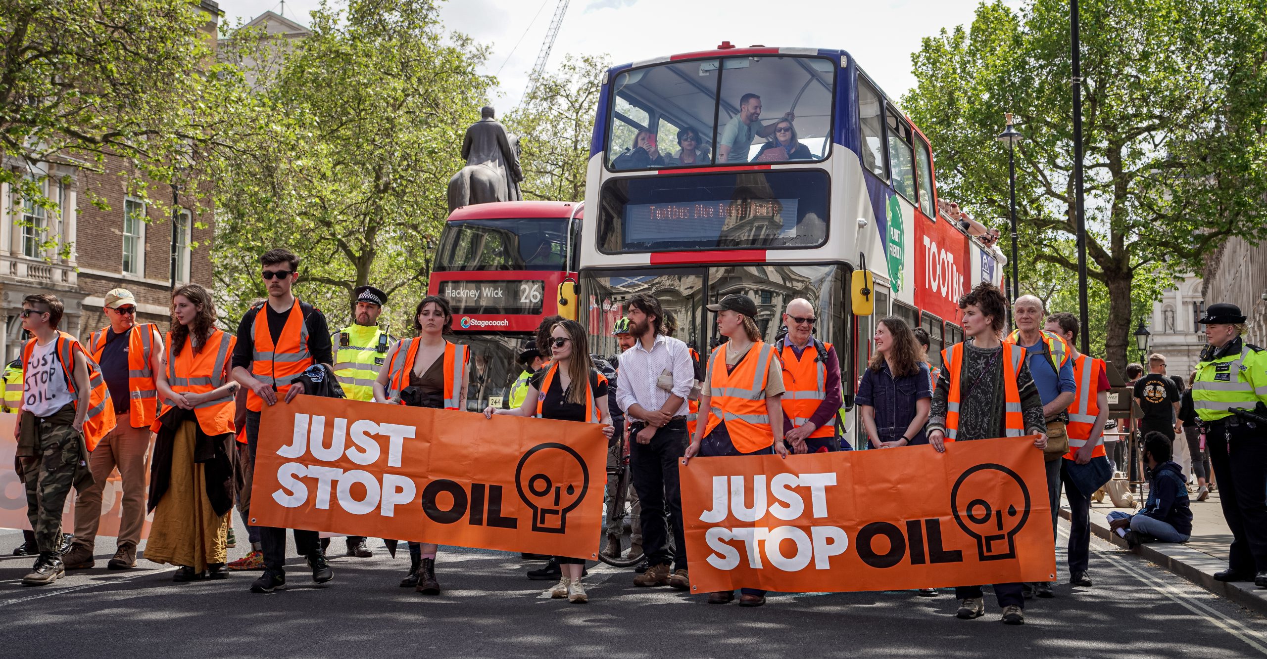 Activisten van Just Stop Oil, Whitehall, Londen, Verenigd Koninkrijk (Foto: Alisdare Hickson, <a href='https://commons.wikimedia.org/wiki/File:Just_Stop_Oil_Activists_Walking_Up_Whitehall.jpg' target='_blank'>Wikimedia Commons</a>)