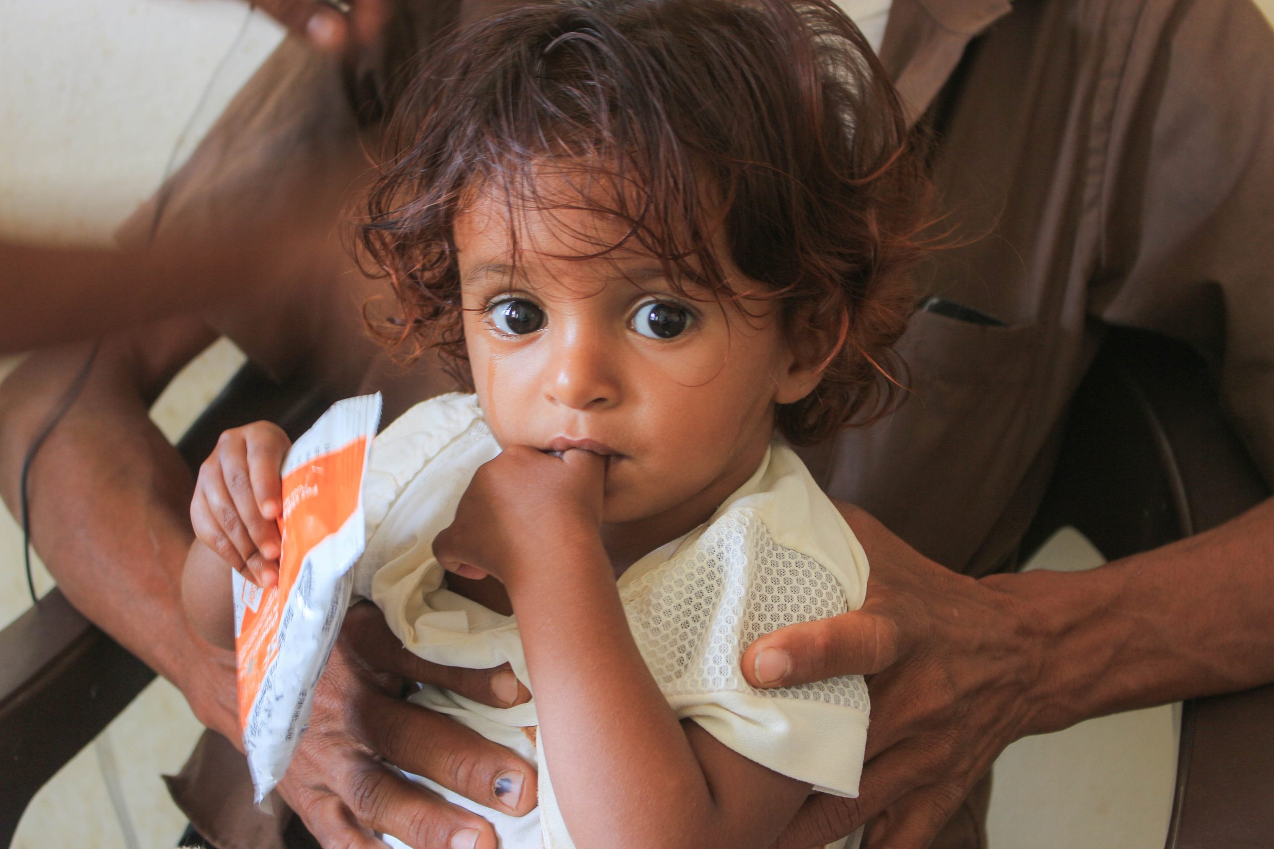 Kind met voedselhulp van Wereldvoedselprogramma (Foto: WFP/Issa Al-Raghi, <a href='https://commons.wikimedia.org/wiki/File:Nutrition_Issa-Al-Raghi.jpg' target='_blank'>Wikimedia Commons</a>)