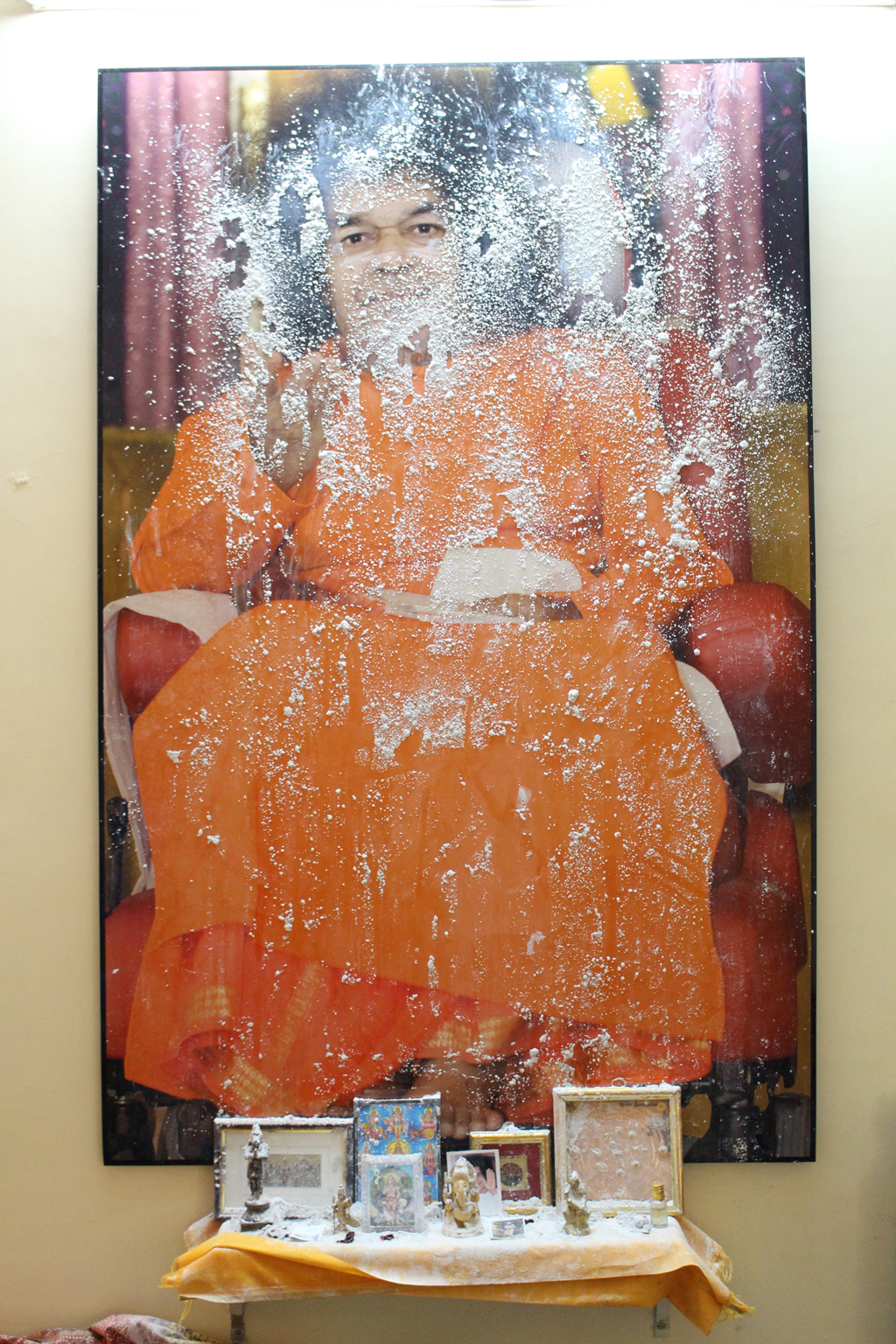 In de kamer van een devotee in de ashram van Sai Baba in Puttaparthi, India, is op een grote foto van Sai Baba een uitstorting van vibhuti te zien. Ingezonden door P.L., VK. <em>(Benjamin Creme’s Meester bevestigt dat dit wonder door Sai Baba werd gemanifesteerd.)</em>